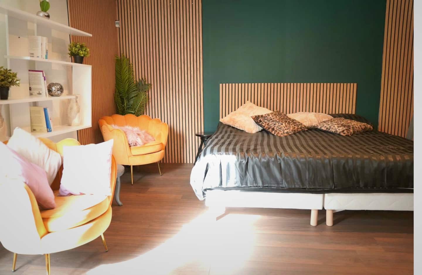 Vue d'ensemble de la chambre : lit double, tête de lit en tasseaux, fauteuils